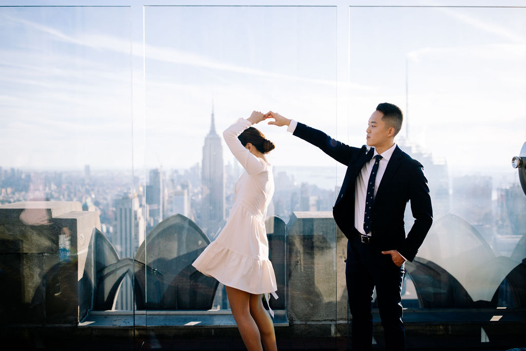 Couple twirling on the top of the rock 